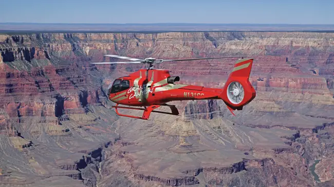 Helicopter flying over the vast and red valleys of Grand Canyon