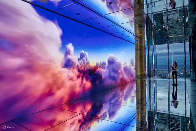 Tourists in the mirror room of Summit One Vanderbilt with a view of New York City skyline